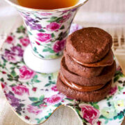 Earl Grey Ganache Filled Cookies stacked on plate with tea.
