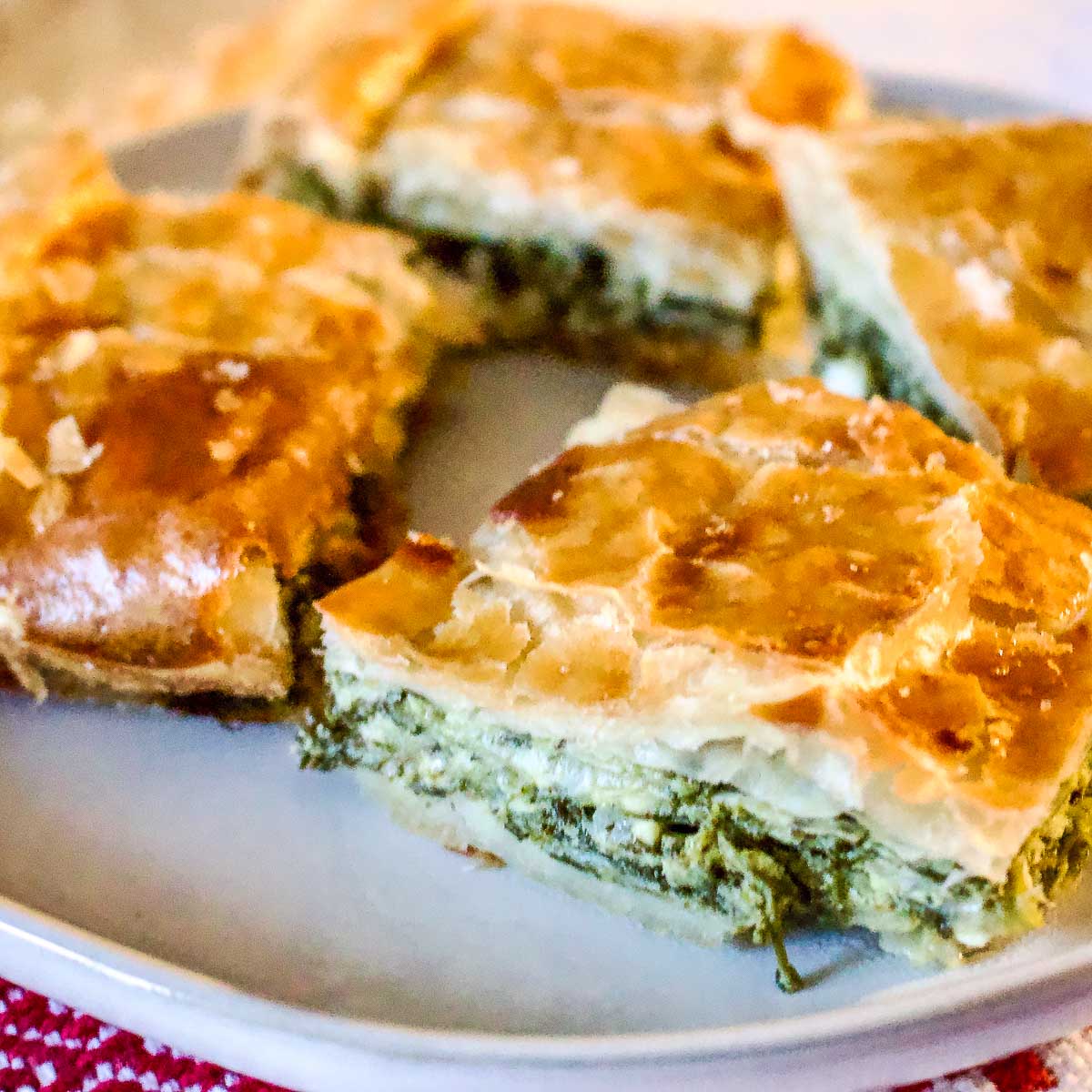 Slices of Spinach Feta Cheese Pie on a platter.