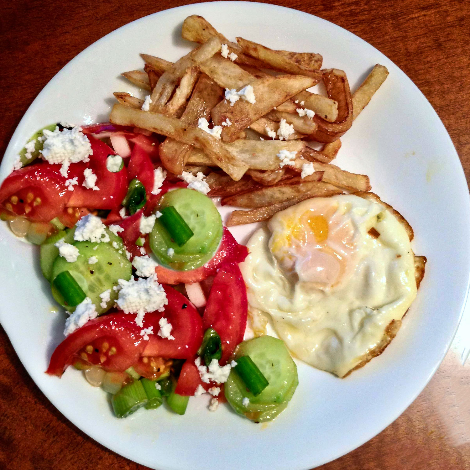 French Fries with tomato salad and egg on white plate0