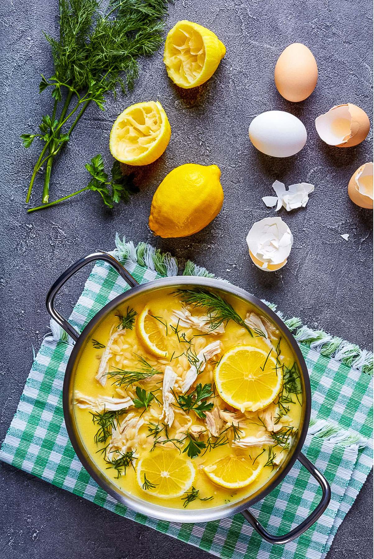 Greek Lemon Chicken Soup overhead image- with lemons, eggs and dill on the table