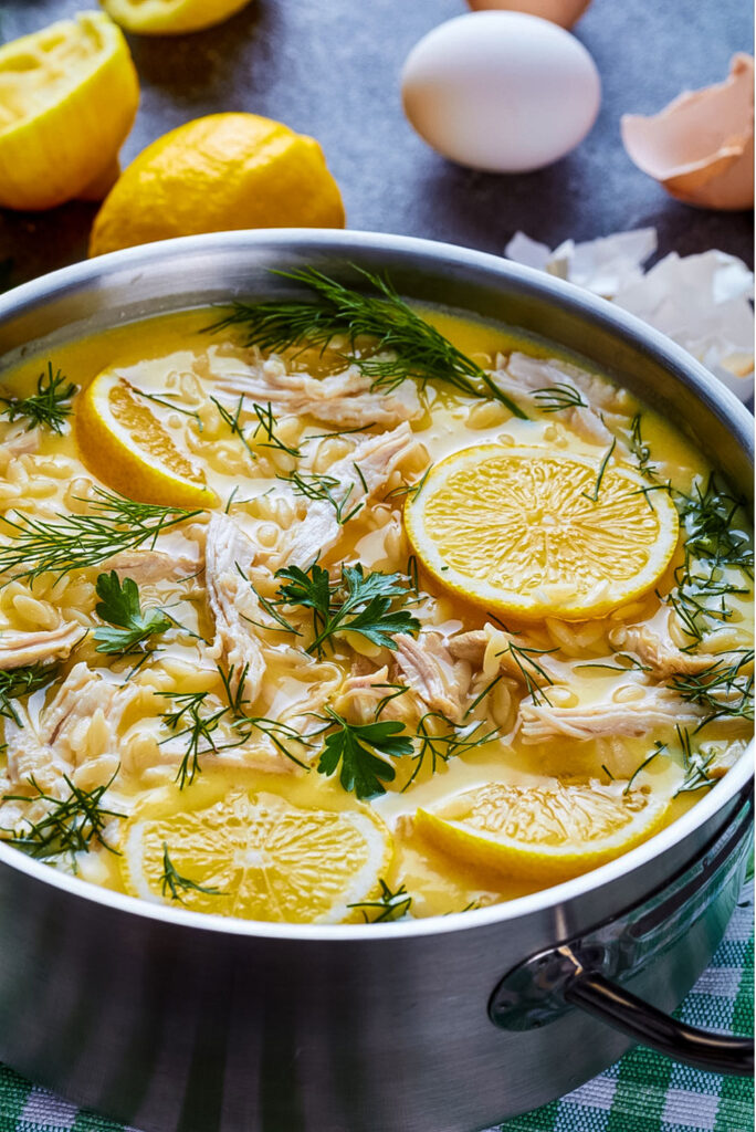 Greek Lemon Chicken Soup with lemons and eggs close up0