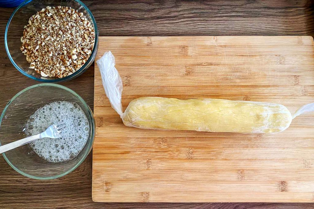 Dough with walnuts and egg white in bowls0