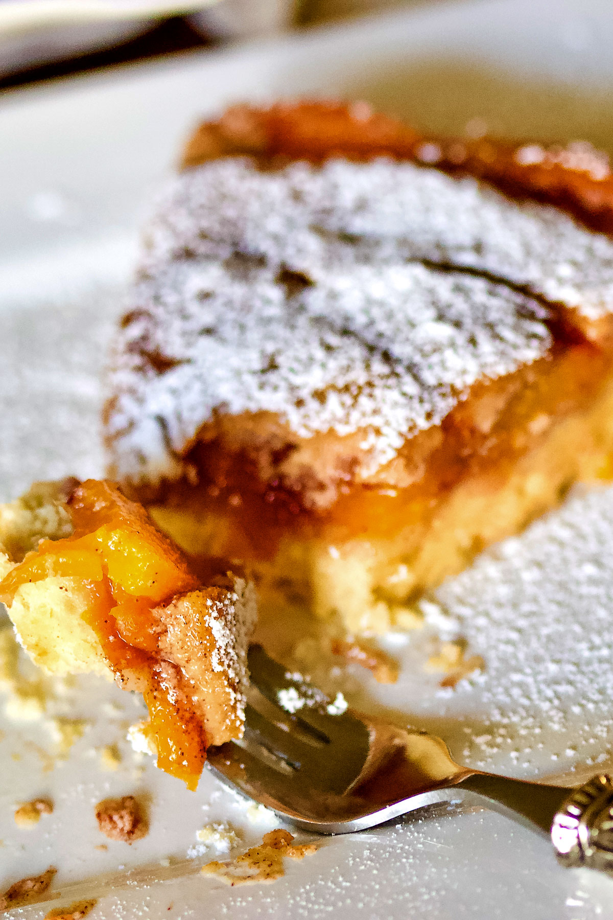 German Peach Kuchen- a Transylvanian dessert made with peaches, custard and a shortbread crust. Delicious, easy to make and perfect for summer. Peach Kuchen slice with fork0