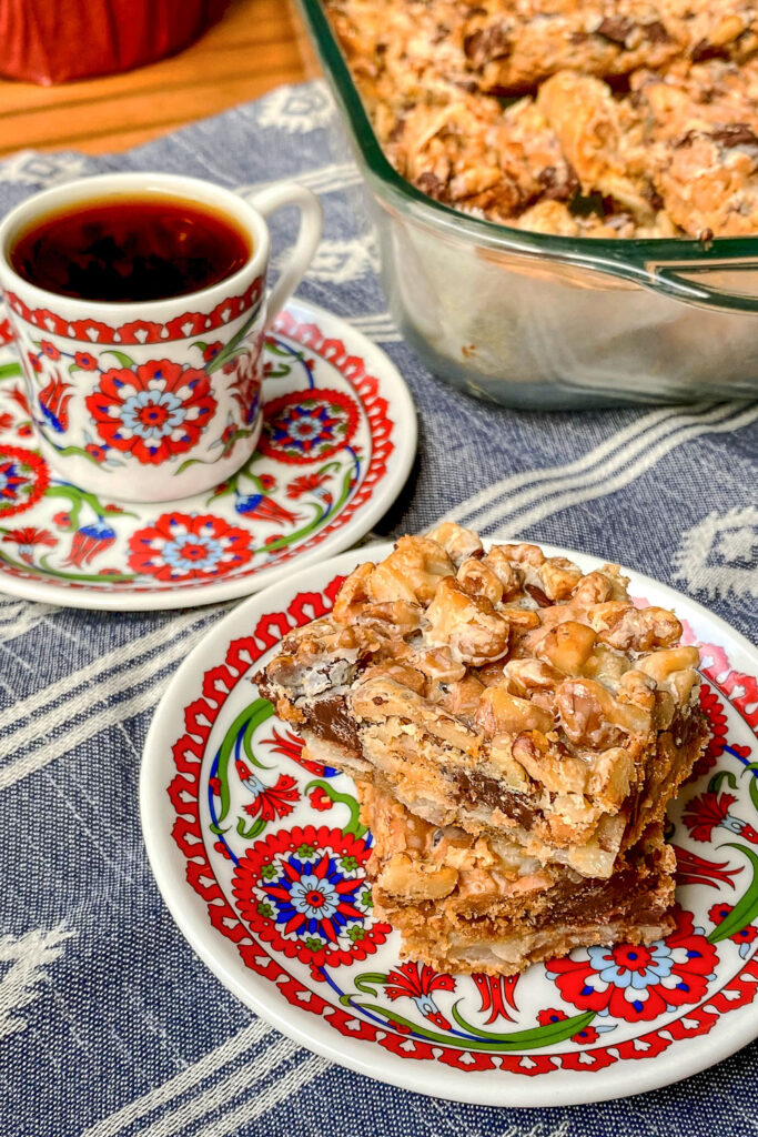 Seven Layer Bars on plate with coffee cup.