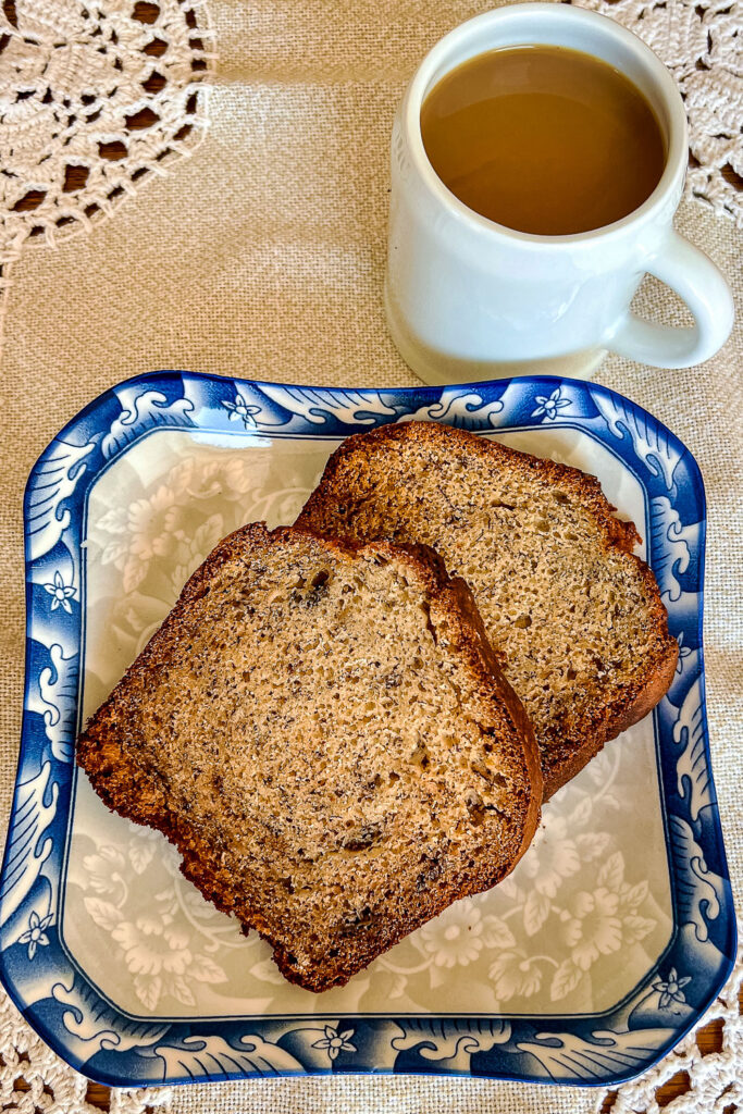 Slices of banana bread on blue and white plate with cup of coffee0