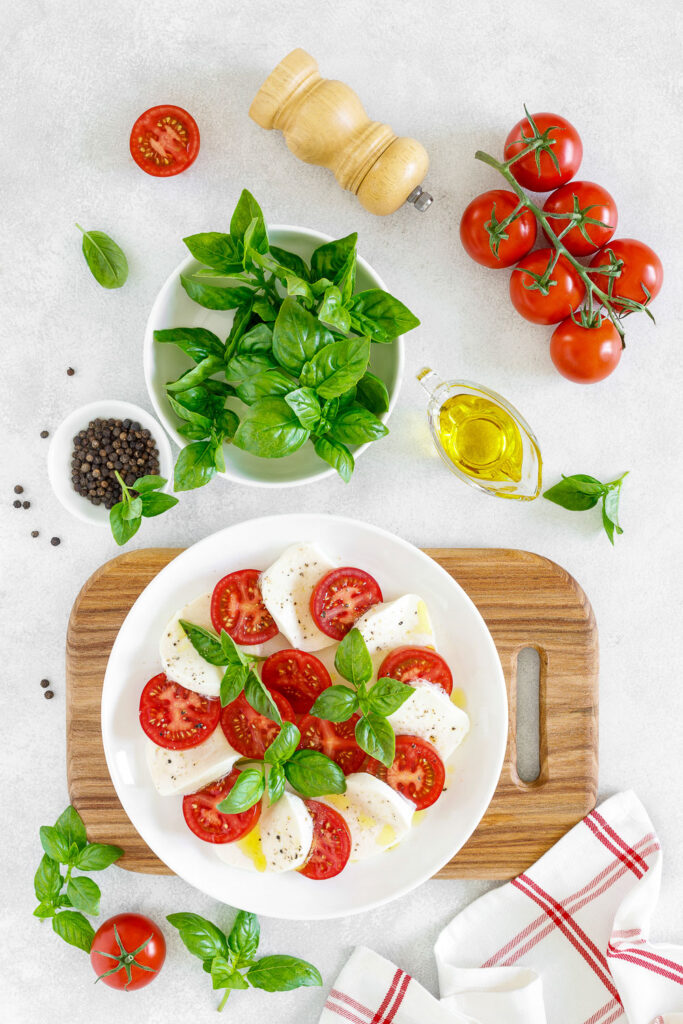 Caprese Salad on white background with ingredients around0