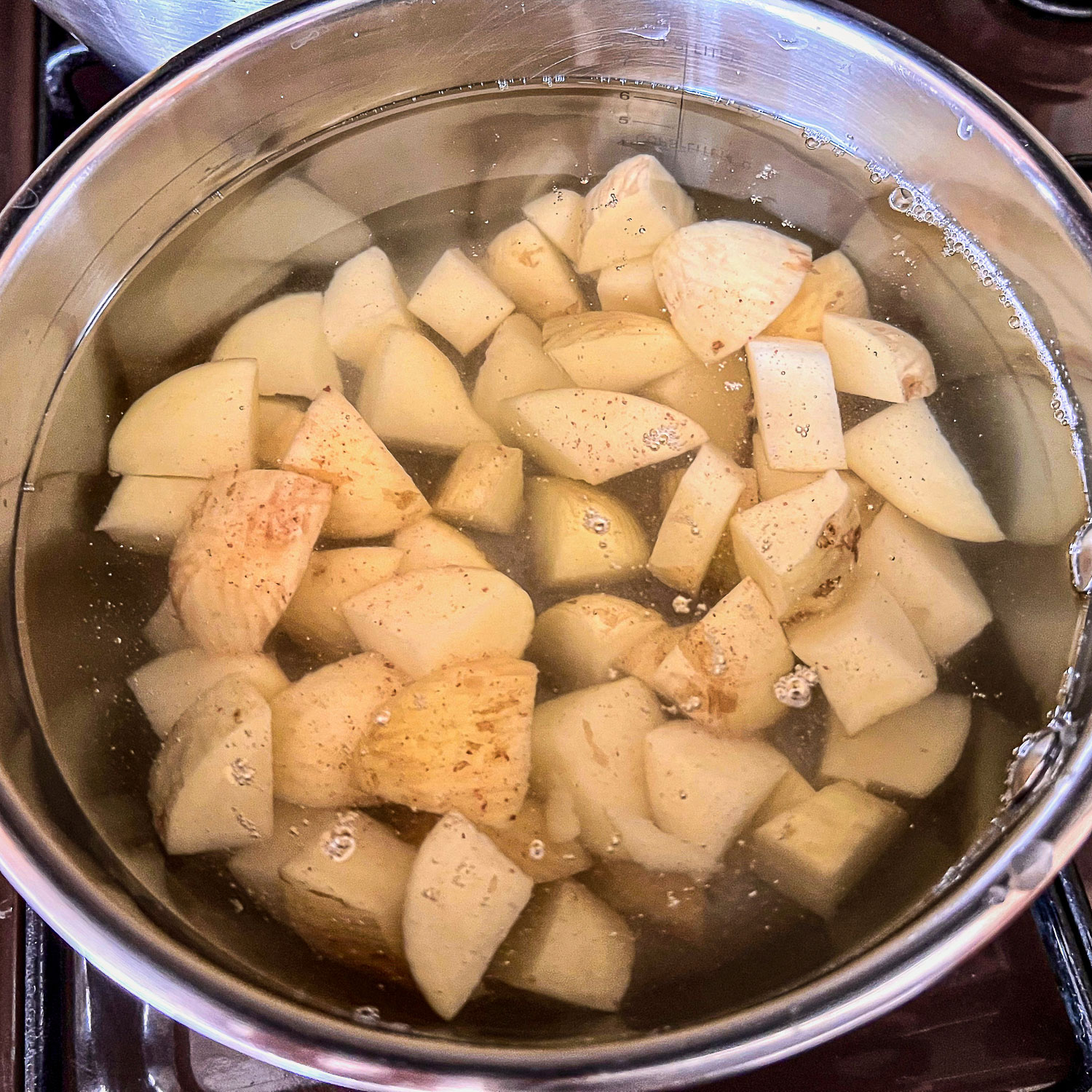 Cubed potatoes in a pot with water for Tinga Poblana