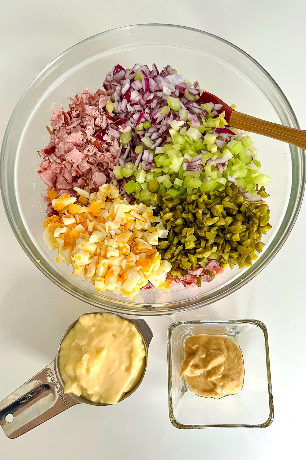 Chopped ingredients in a bowl with mayo and mustard separately