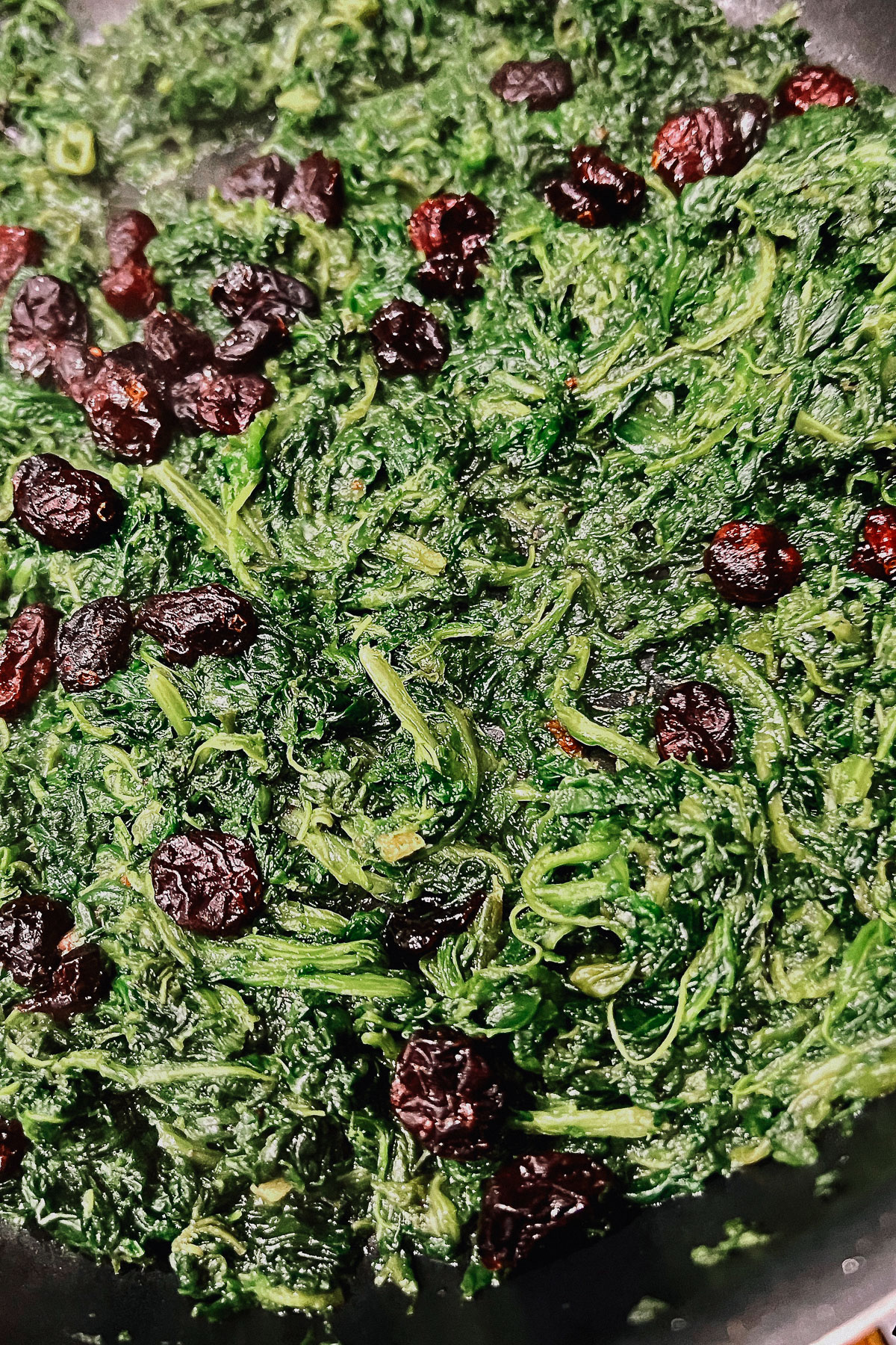 Spinach and cranberries cooking in the pan0