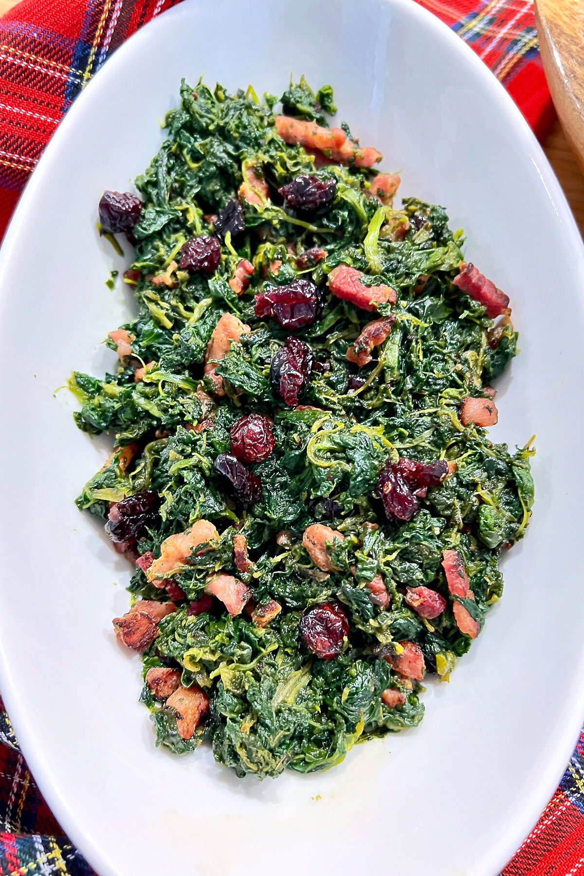 Spinach with bacon in a white bowl.