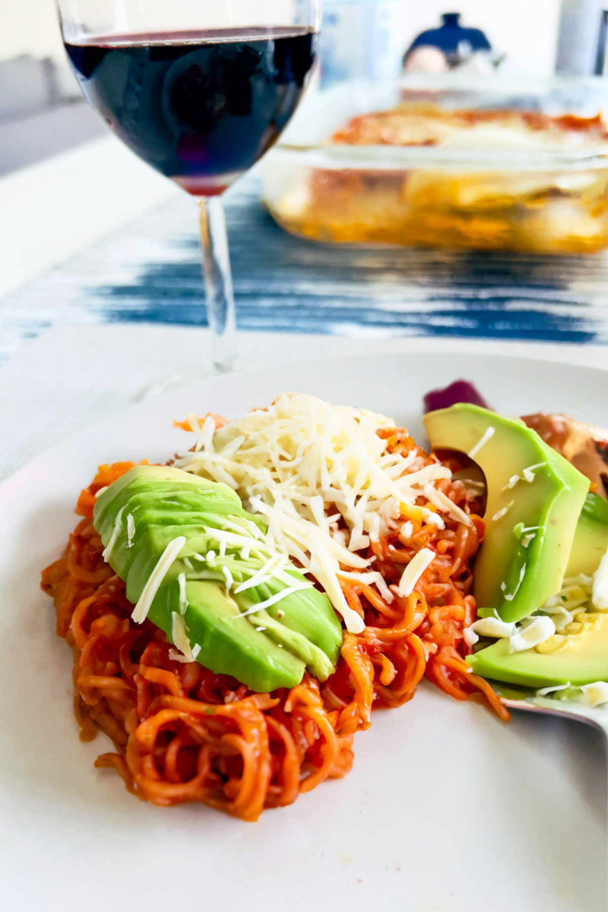 Sopa Seca on a plate with a glass of red wine in the background