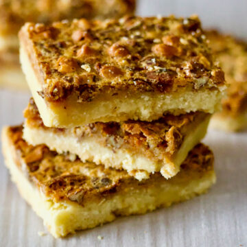 Butterscotch Pecan Pie Bars on parchment paper square image0