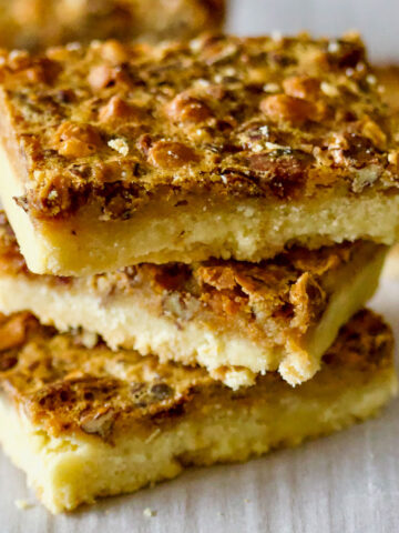 Butterscotch Pecan Pie Bars on parchment paper square image0
