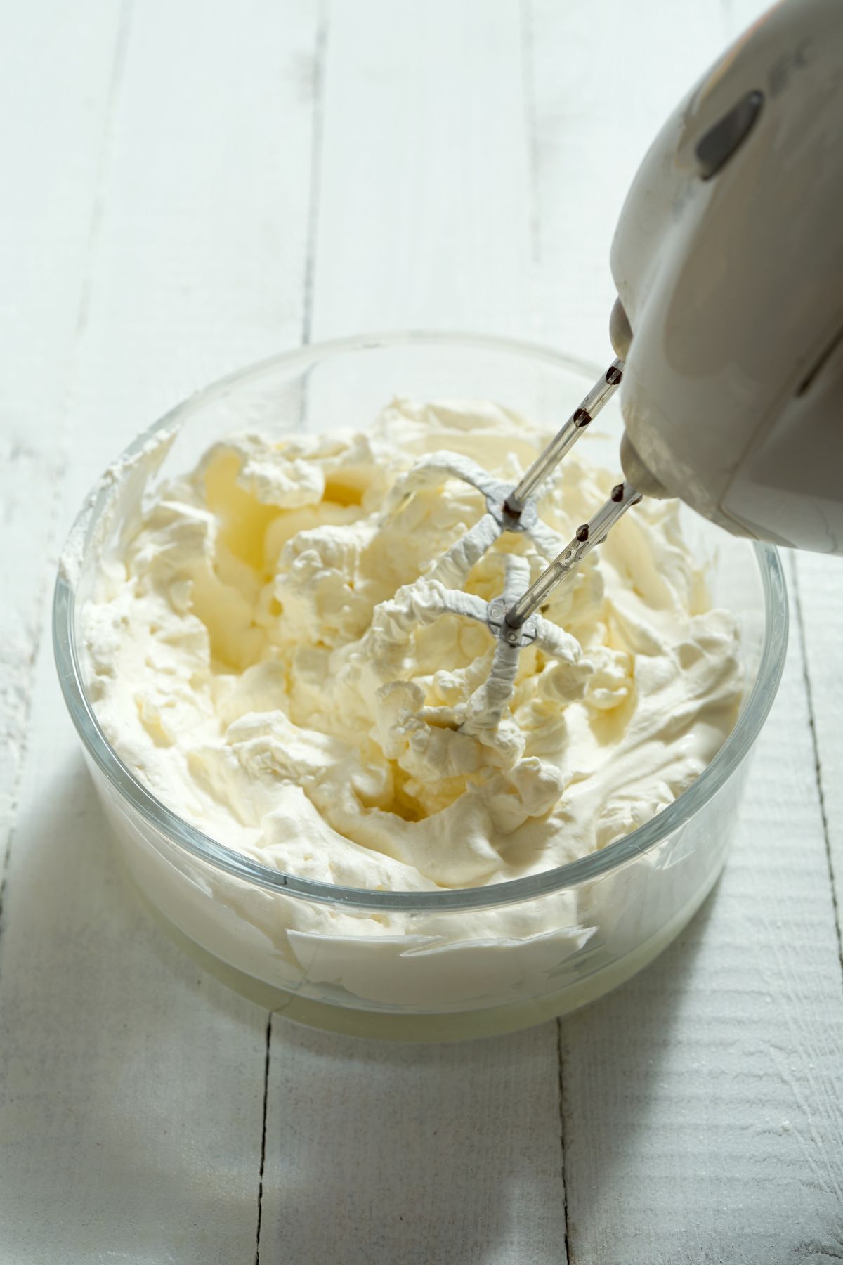 Whipped cream in a bowl with mixer