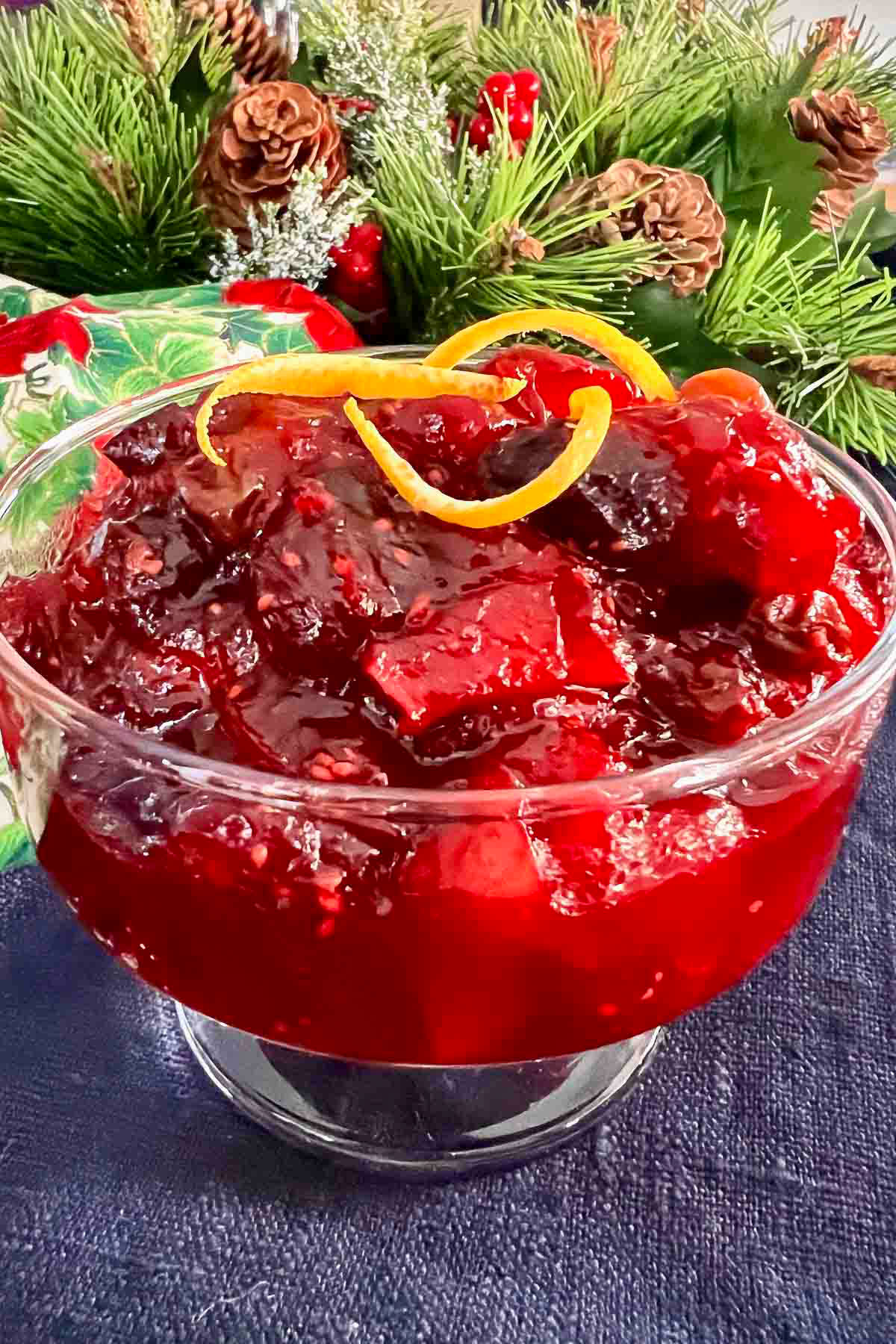 Cranberry Chutney in a glass bowl with holiday decorations in the background.