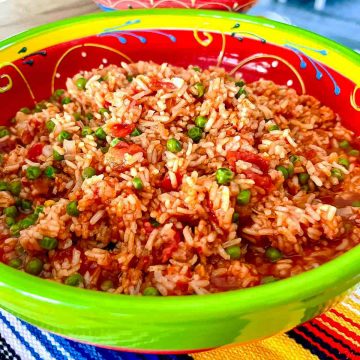 Mexican red rice (Arroz A La Mexicana) with onions garlic and peas.