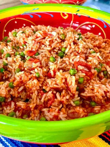 Mexican red rice (Arroz A La Mexicana) with onions garlic and peas.