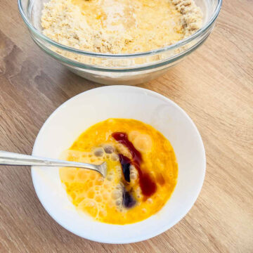 Eggs mixed with vanilla in a white bowl.