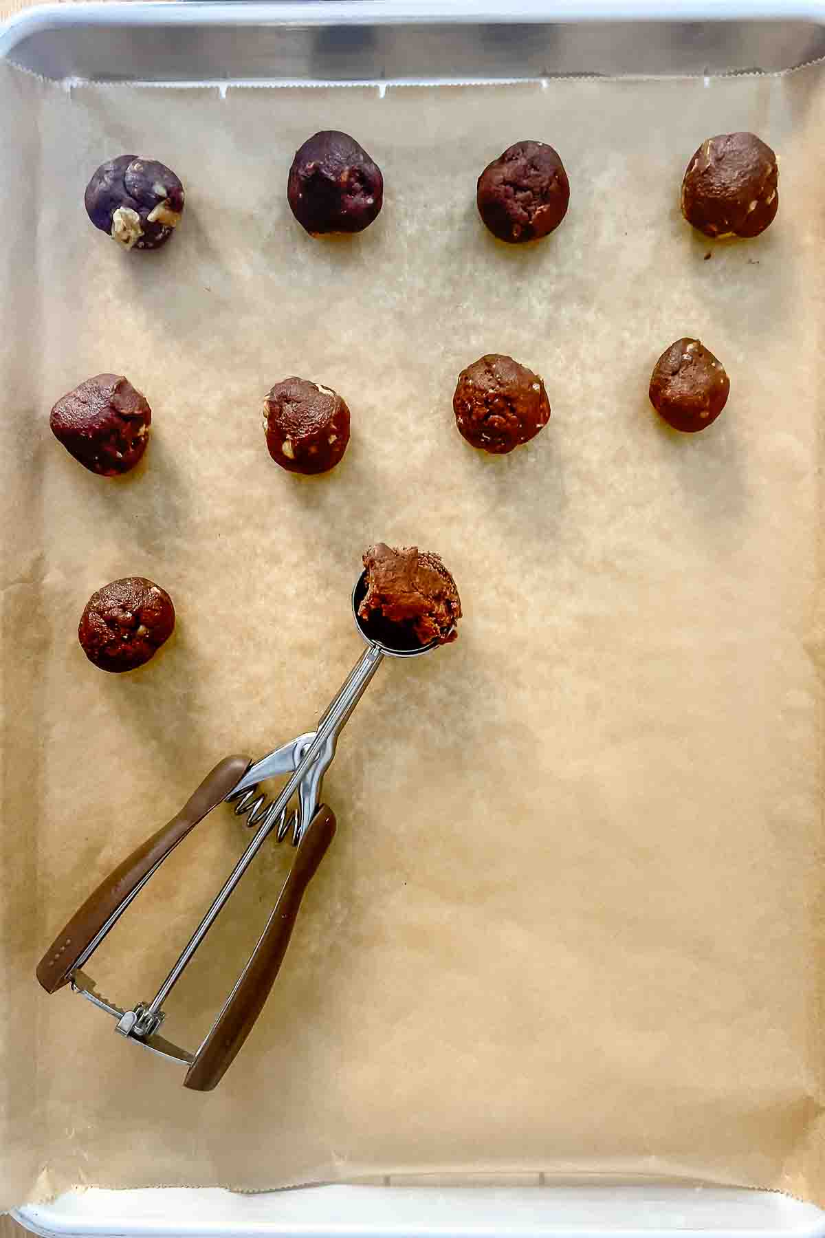 Forming the dough into balls and placing them on a baking sheet.