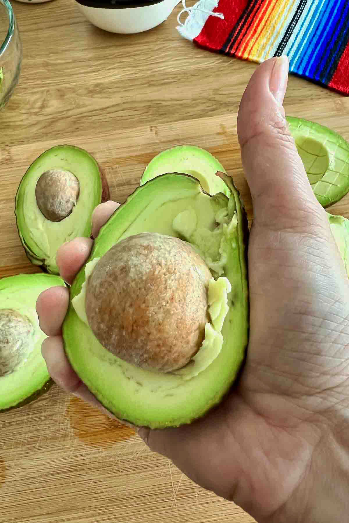 Avocados sliced in half with the pit attached.