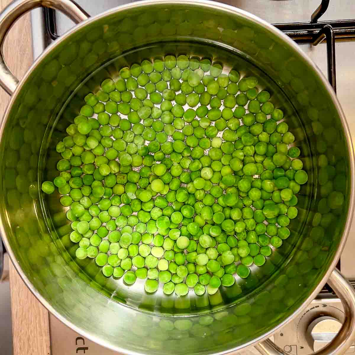 Blanching the peas in a pot.
