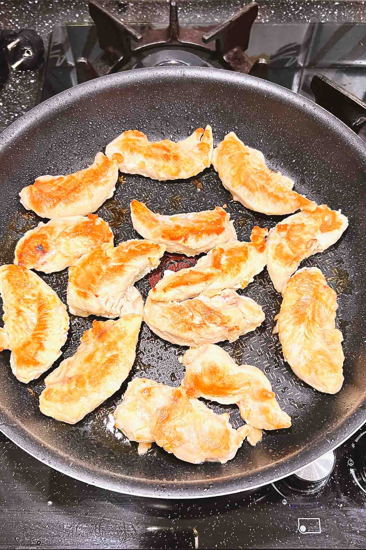 Cooked Chicken cutlets in a pan.