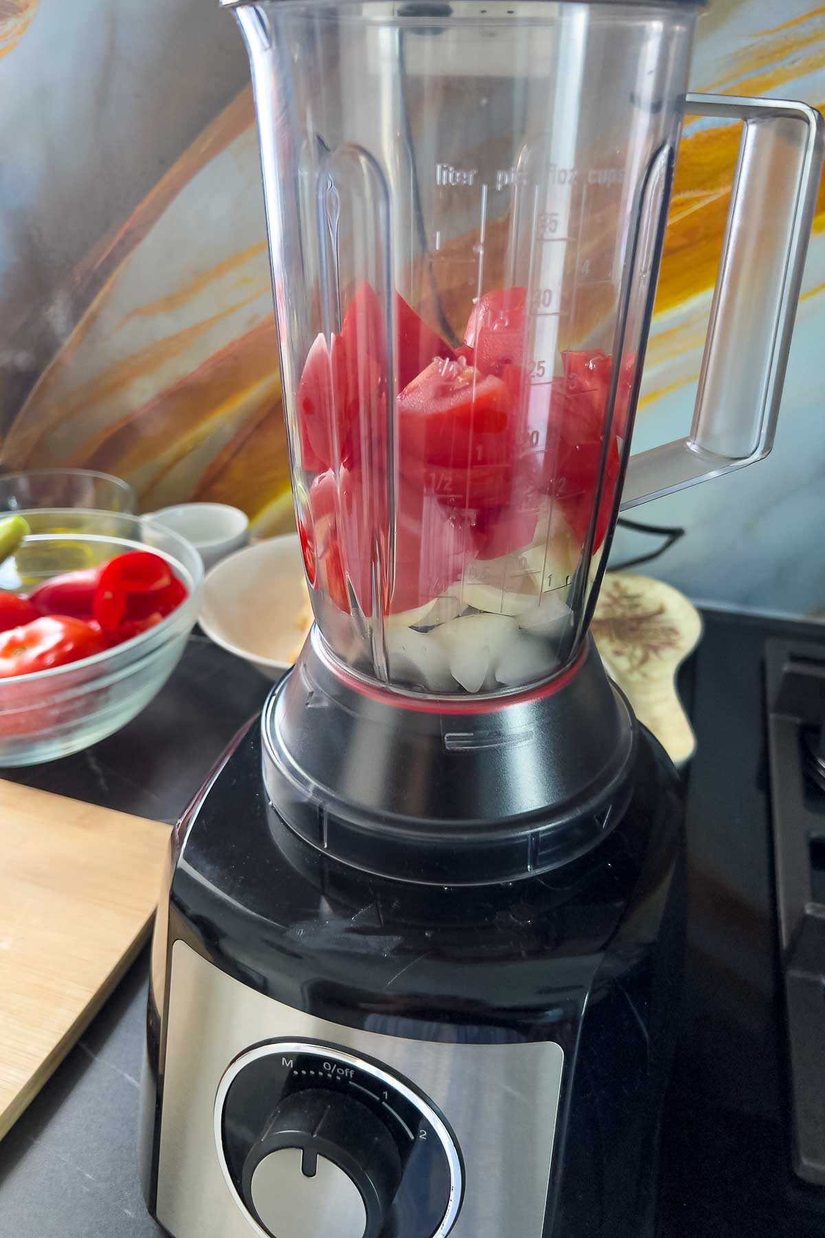 Placing tomatoes in the blender.