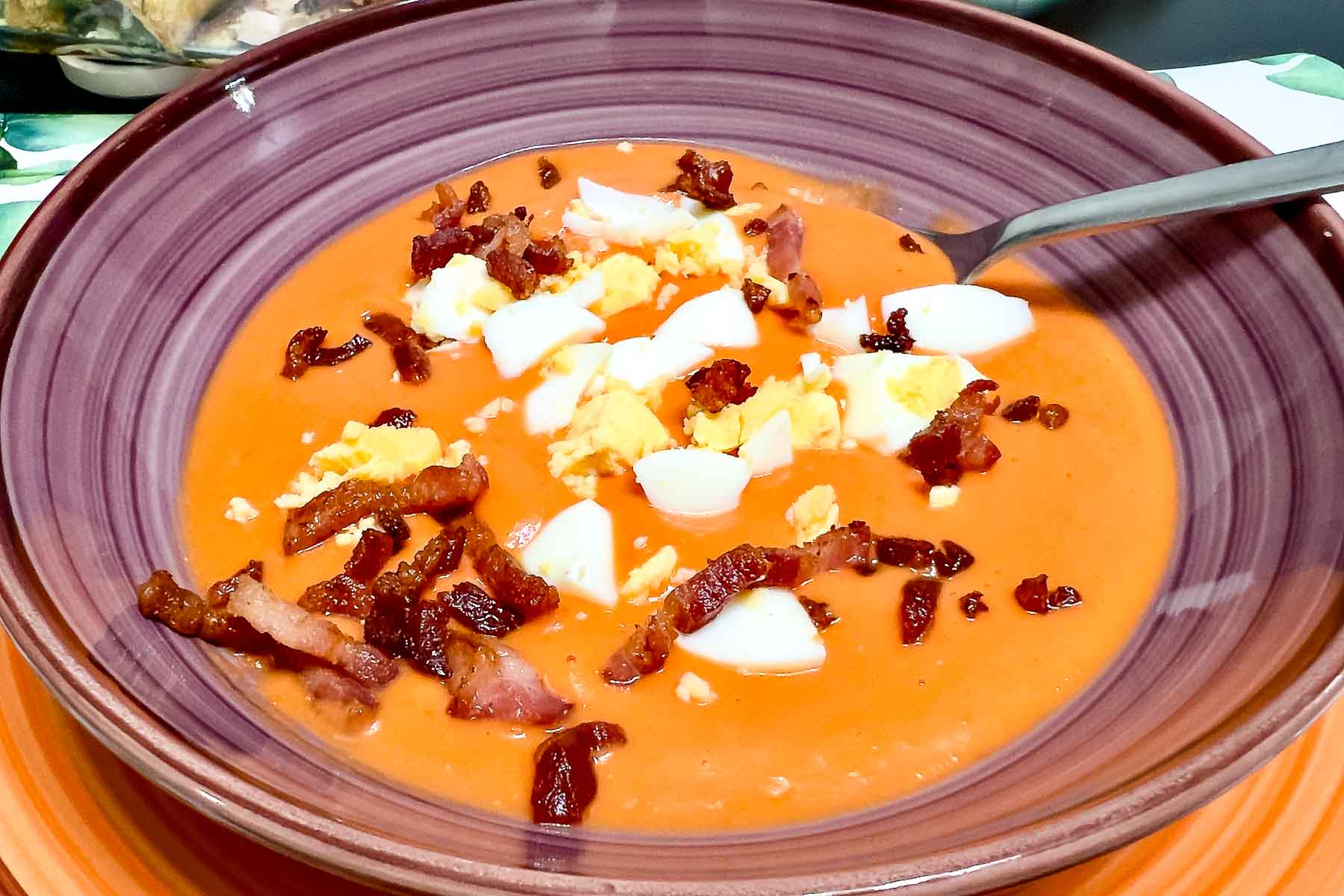 Spanish Porra Soup served with boiled egg and bacon in a bowl.