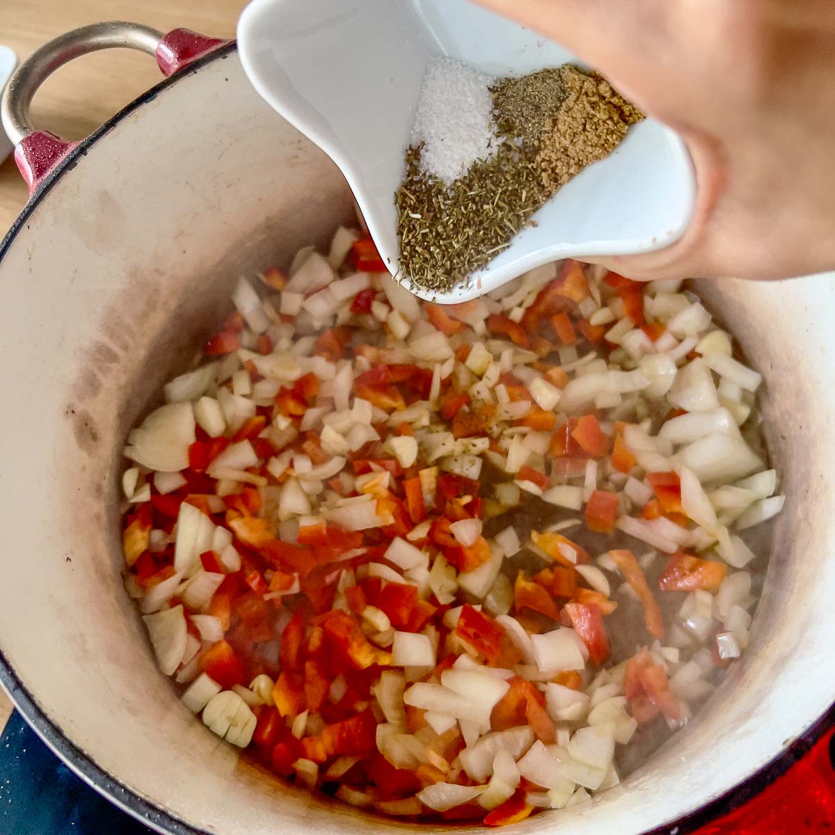 Adding spices to the vegetables.