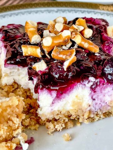 Blueberry Pretzel Salad slice on a plate, with fork.