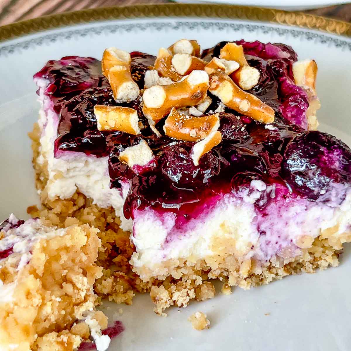 Blueberry Pretzel Salad slice on a plate, with fork.