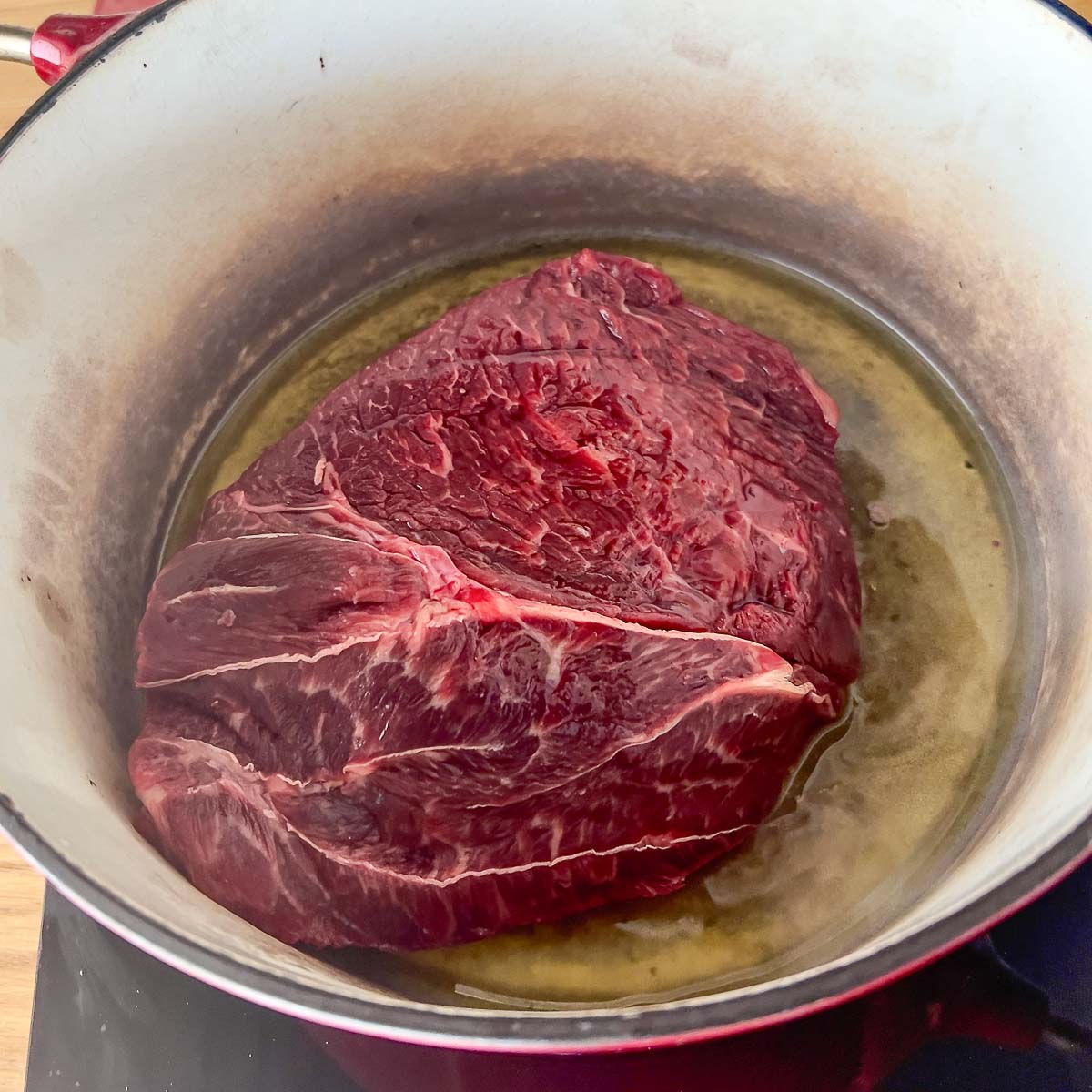 Browning the beef in the Dutch Oven with olive oil.